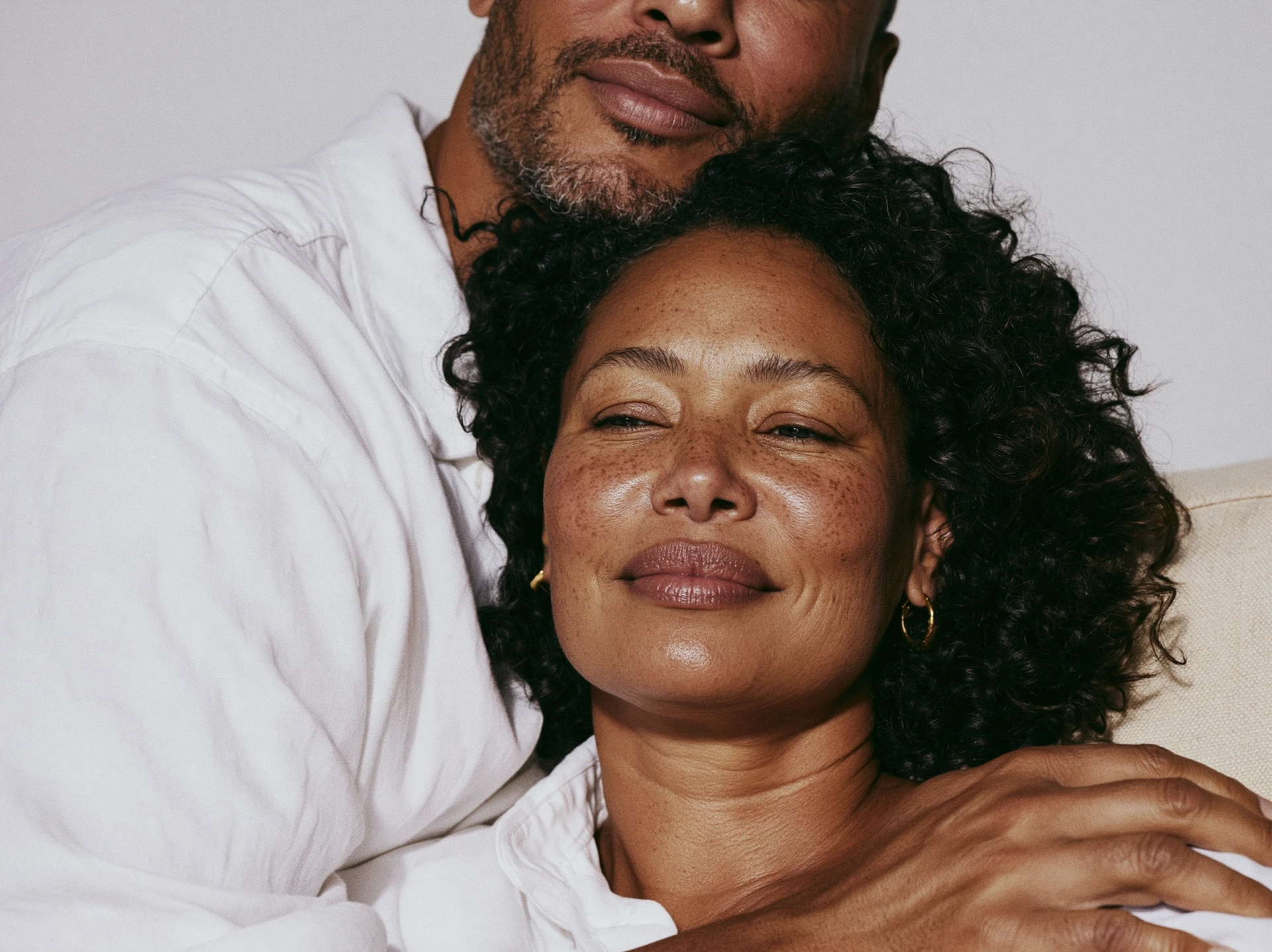 Woman resting calmly against her partner's chest, eyes closed